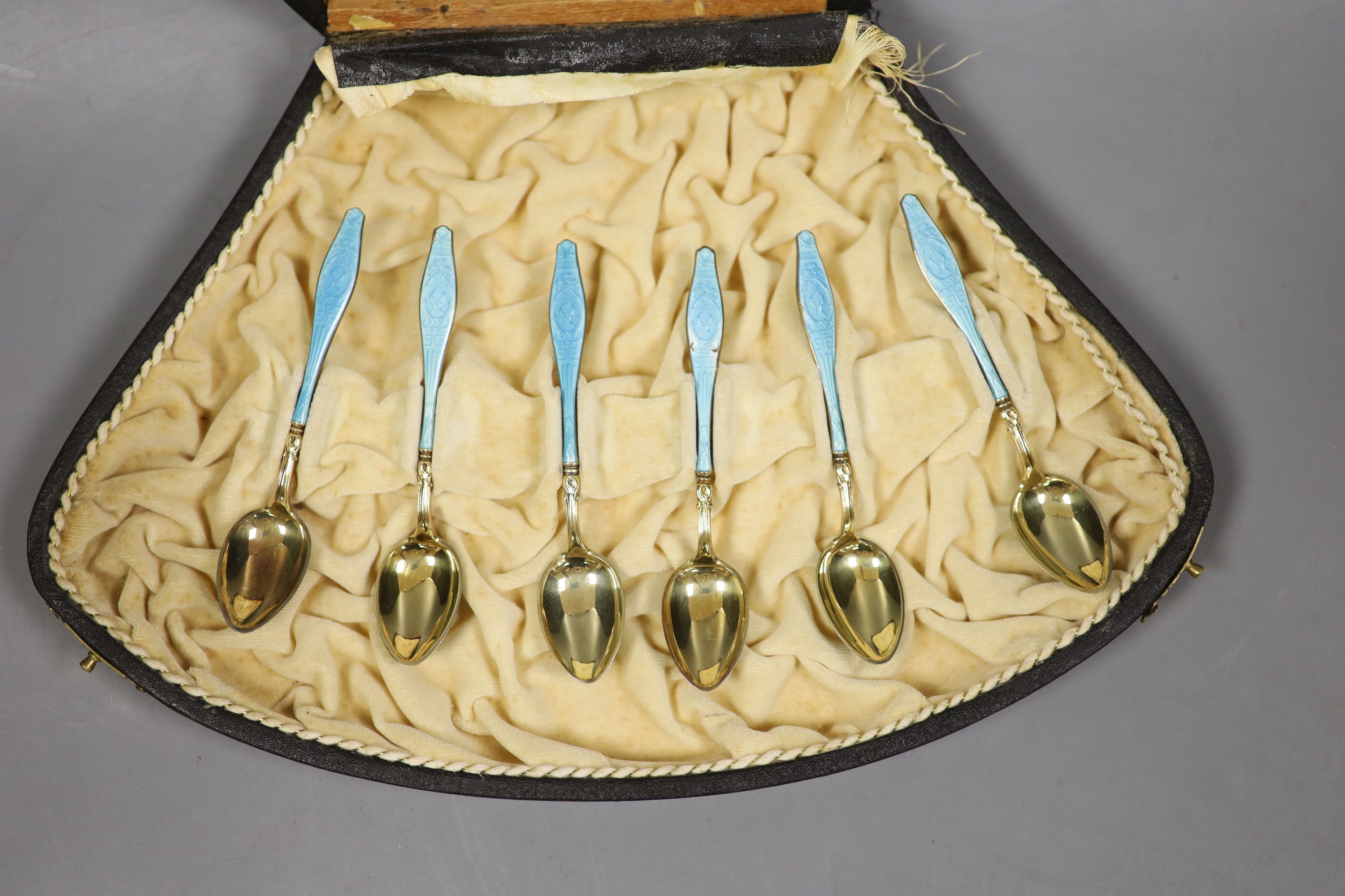 A cased set of six Norwegian gilt white metal and enamel coffee spoons (enamel a.f.).